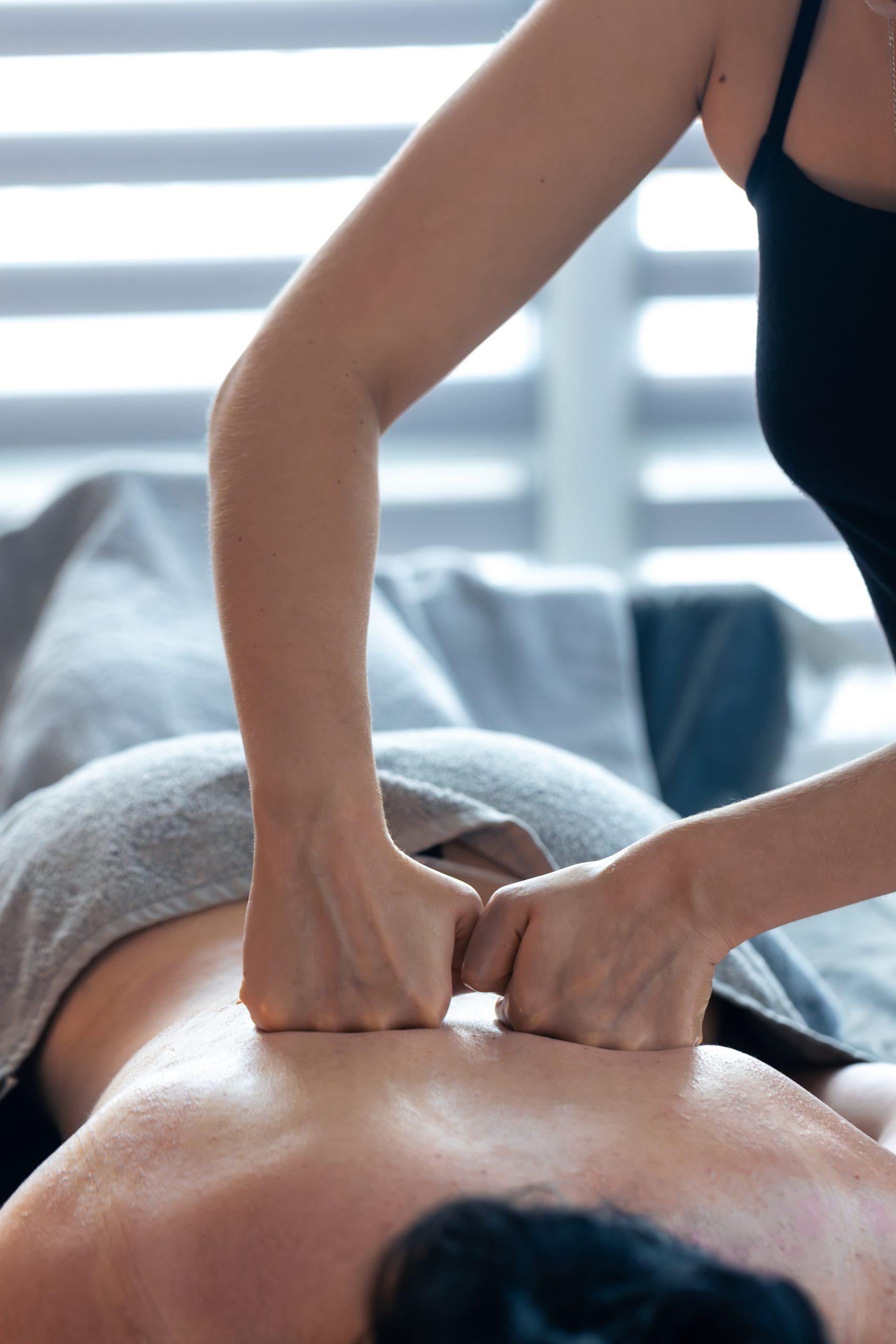Person receiving a deep tissue massage for relaxation and muscle therapy in a serene spa setting.