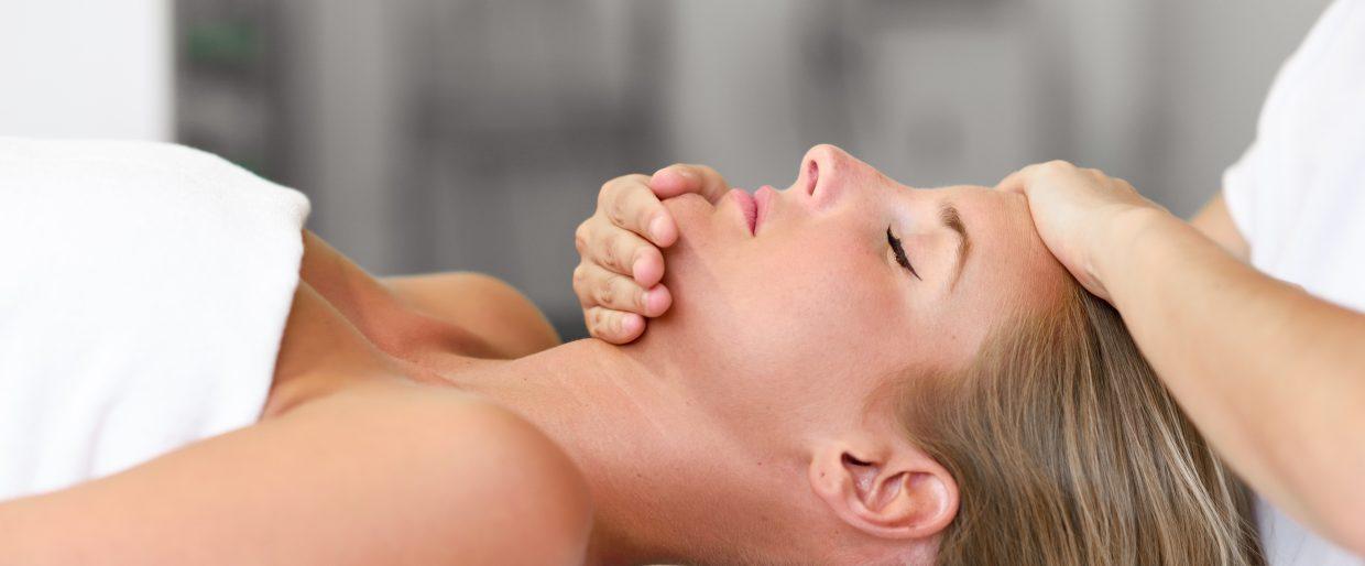 Woman receiving a relaxing facial massage at a spa, promoting wellness and rejuvenation.