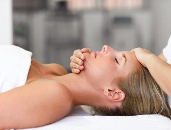 Woman receiving a relaxing facial massage at a spa, promoting wellness and rejuvenation.