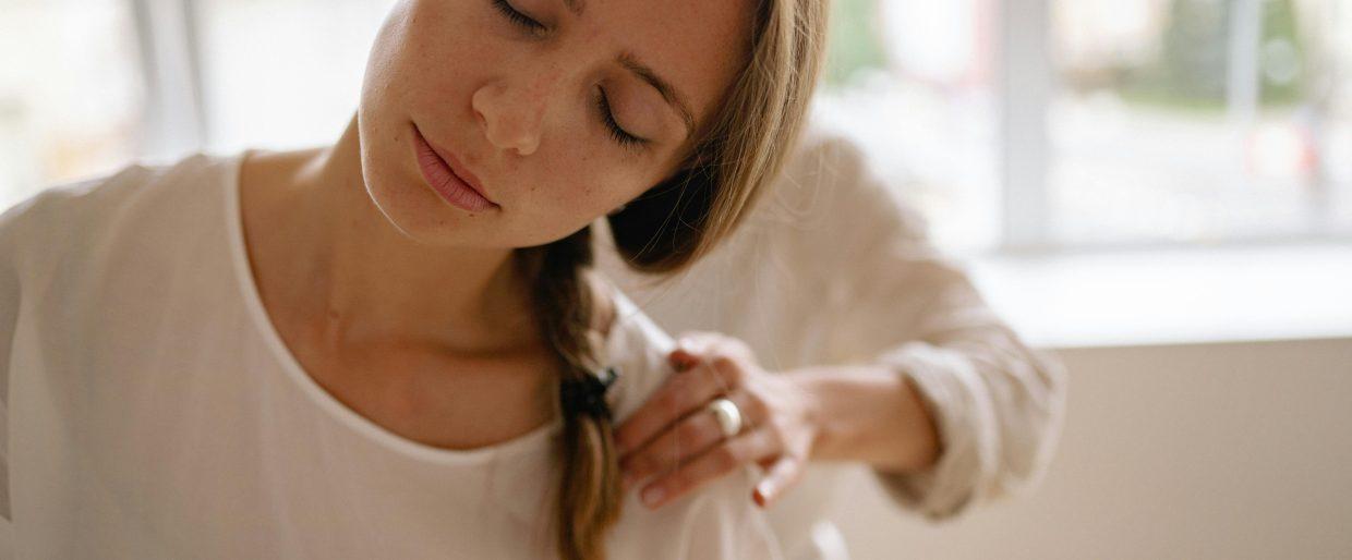 Woman receives relaxing shoulder massage in a bright room.