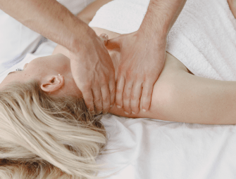 Person receiving a relaxing shoulder massage on a spa table, enhancing relaxation and wellness.